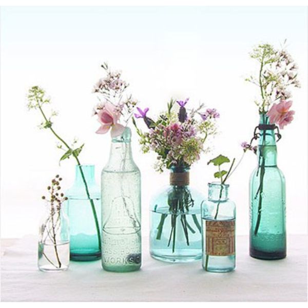 floreros con botellas de vidrio diferentes tipos de flores